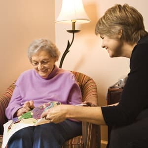 Home care worker providing comfort to an elderly lady