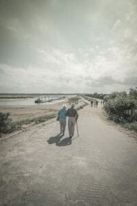 Elderly couple walking outdoors enjoying the smell of sea and fresh air 